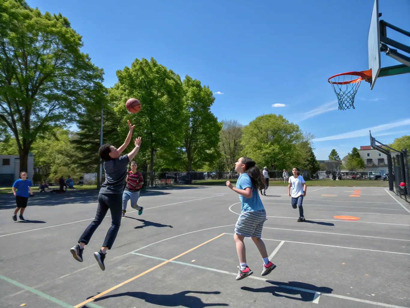A dynamic image of students participating in a basketball game on a university campus, showcasing teamwork and athletic spirit.